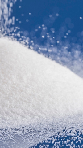 White supersorbent polymers as a fine powder on a blue background.